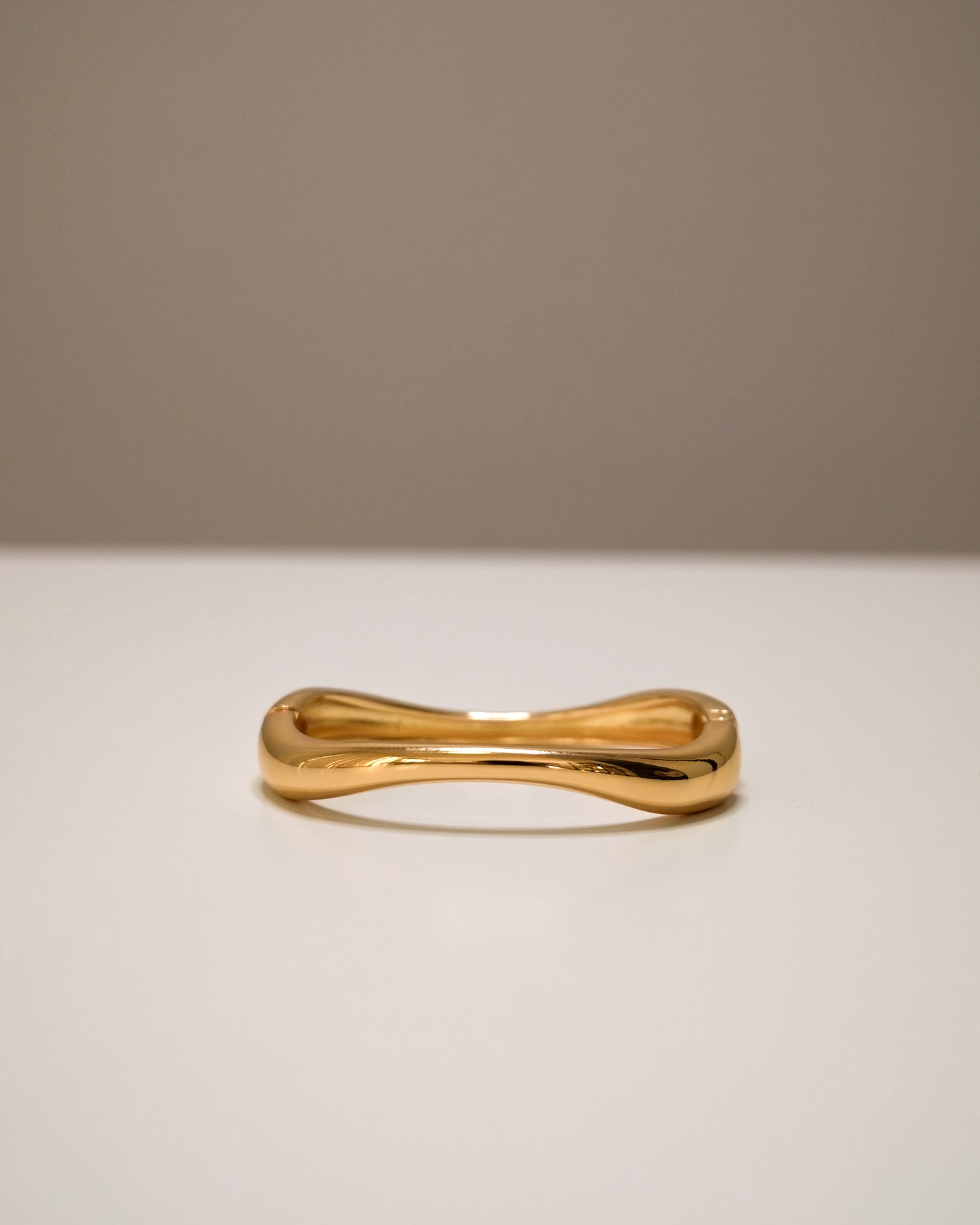 Closed Gold bangle, a modern balance of bold and minimal design.