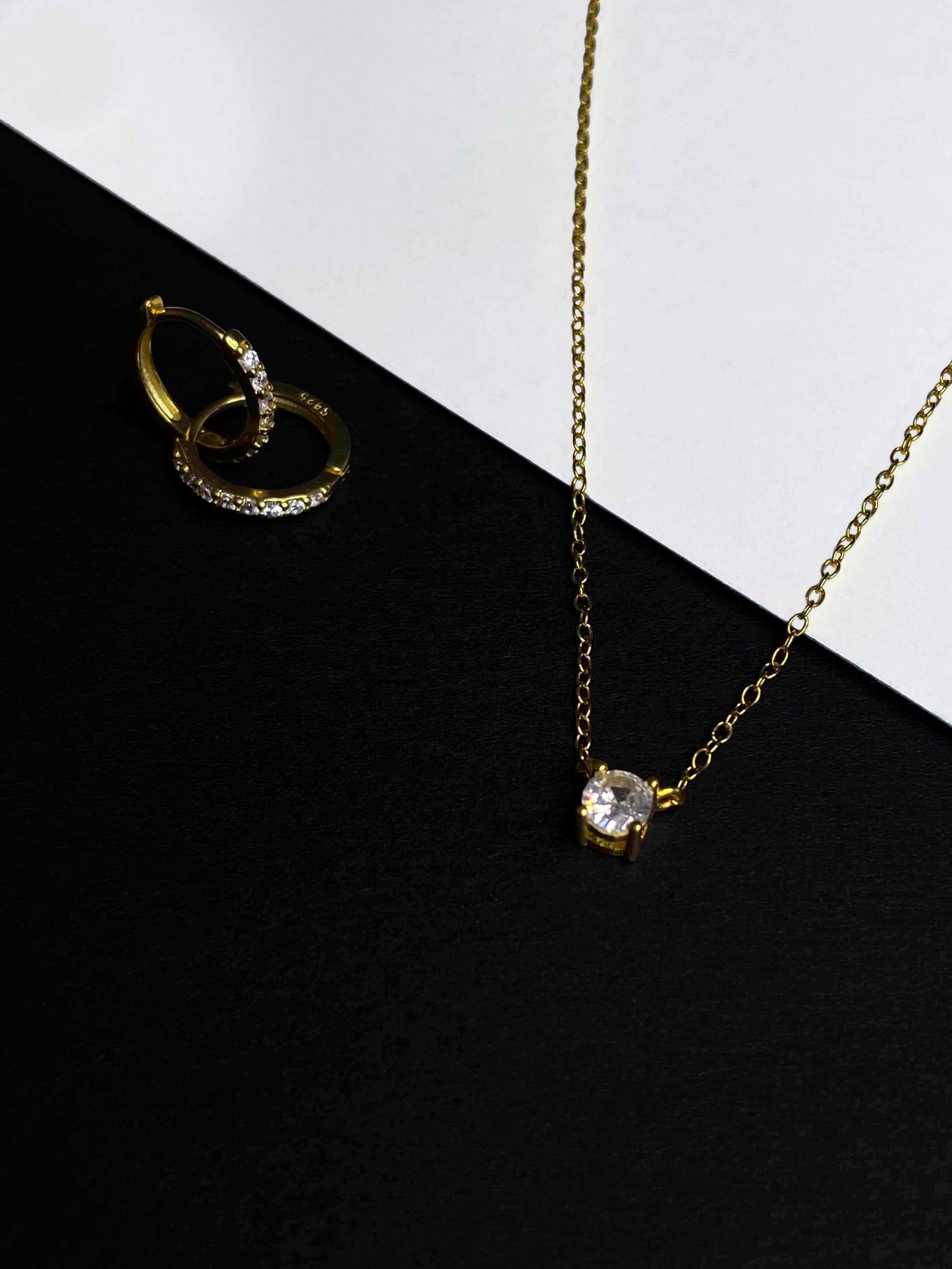 Gold-plated chain link necklace and hoop earrings with zirconia stones.