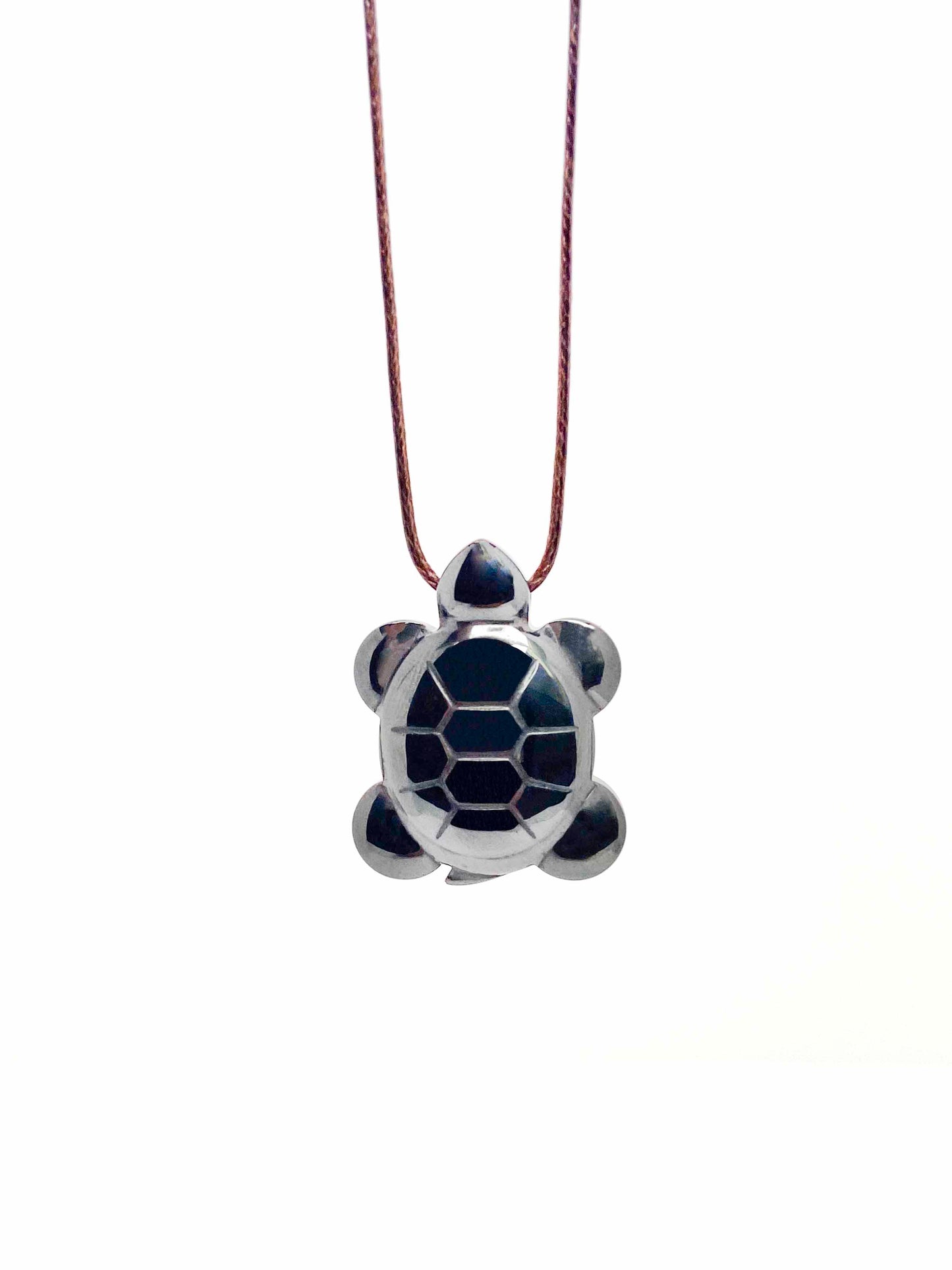 A handmade hematite turtle pendant necklace with brown leather string.