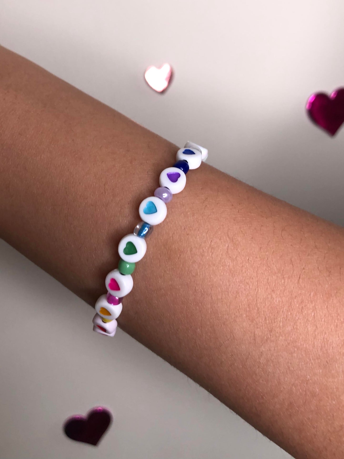 Handmade multicolored heart, letter, and glass beaded bracelet with the word "love".