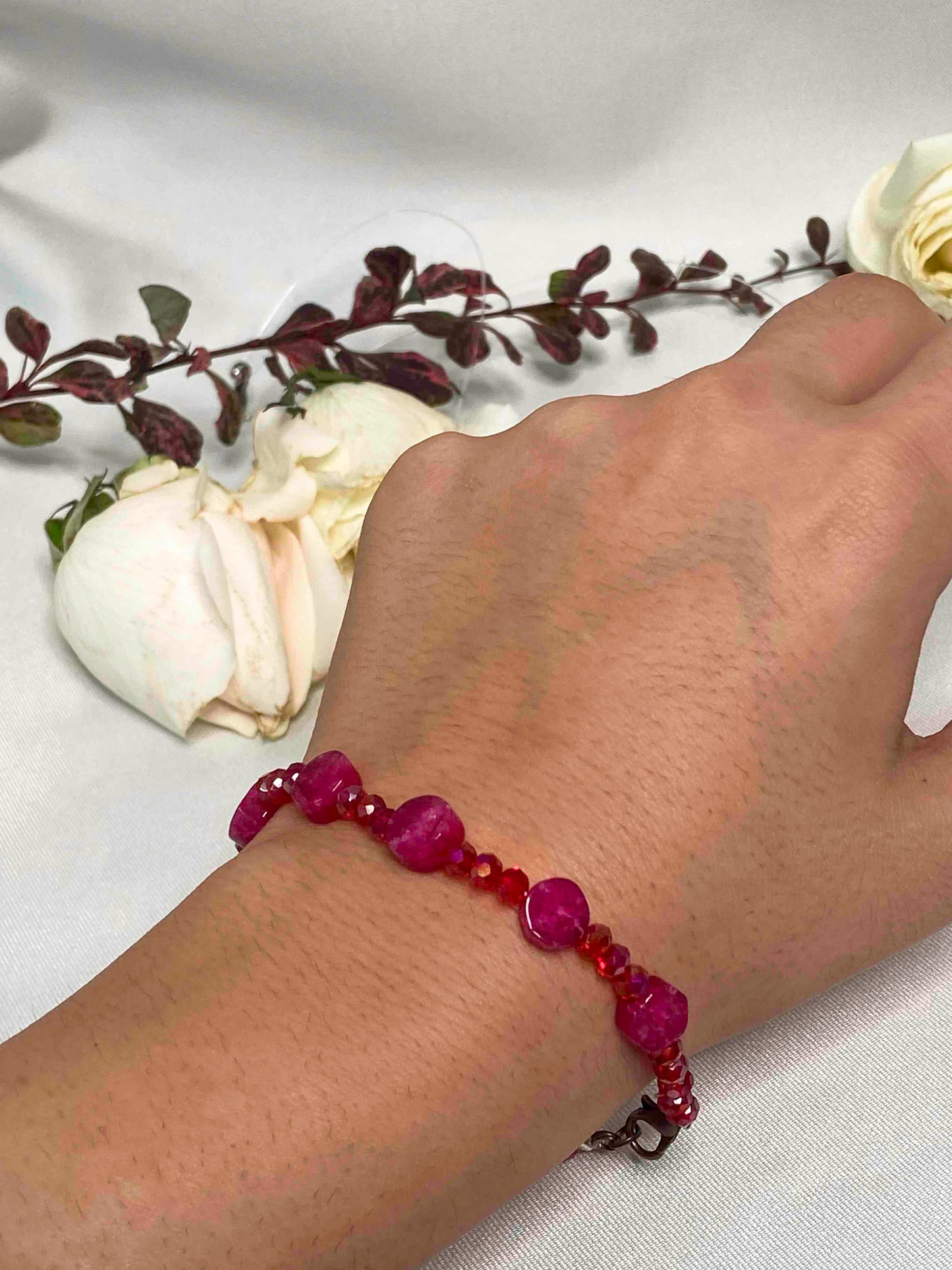 A handmade red crystal bead and pink rubellite stone bracelet.