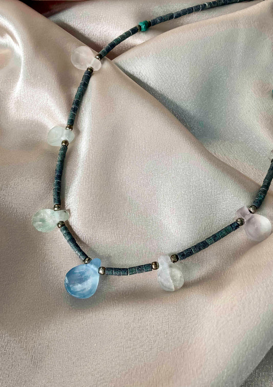 Handcrafted beaded necklace made using carved crystal quartz, turquoise, silver balls, and granite cylinder beads.