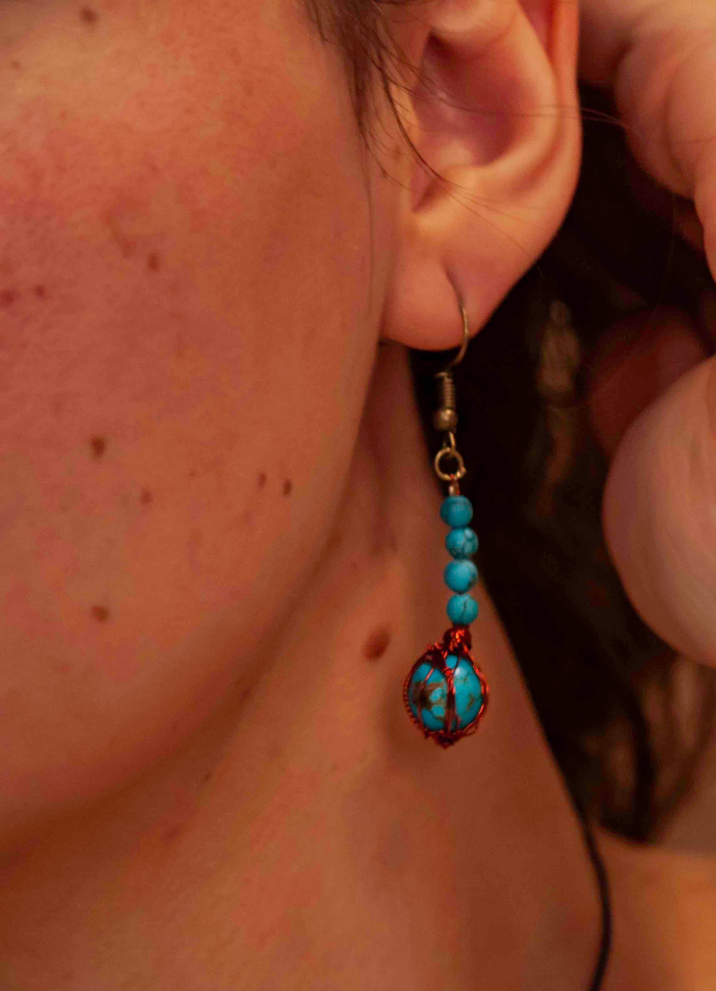 A pair of handcrafted wire-wrapped and beaded turquoise earrings. 