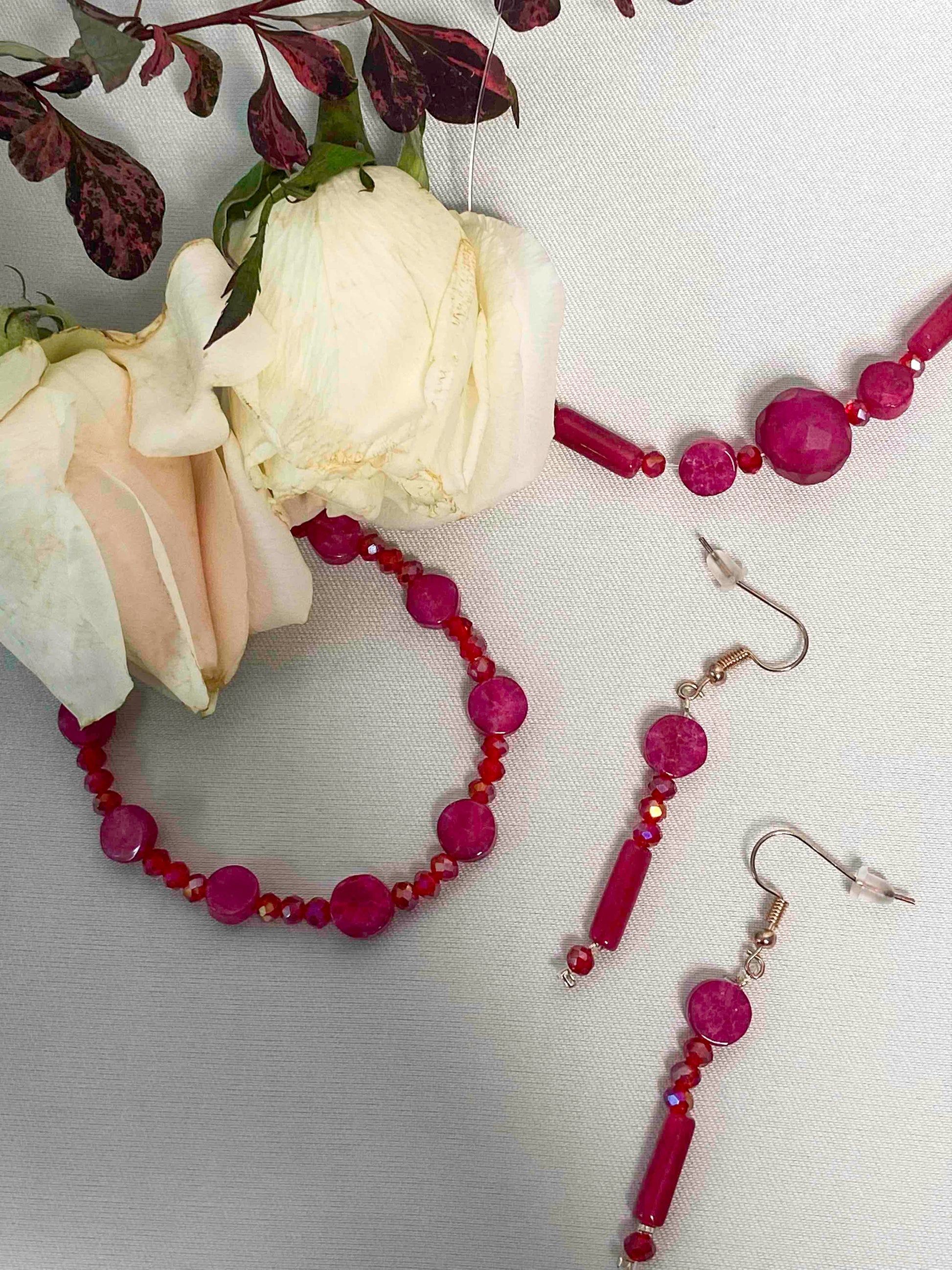 A set of handmade red crystal bead and pink rubellite stone bracelet, pendant necklace, and dangle drop earrings.
