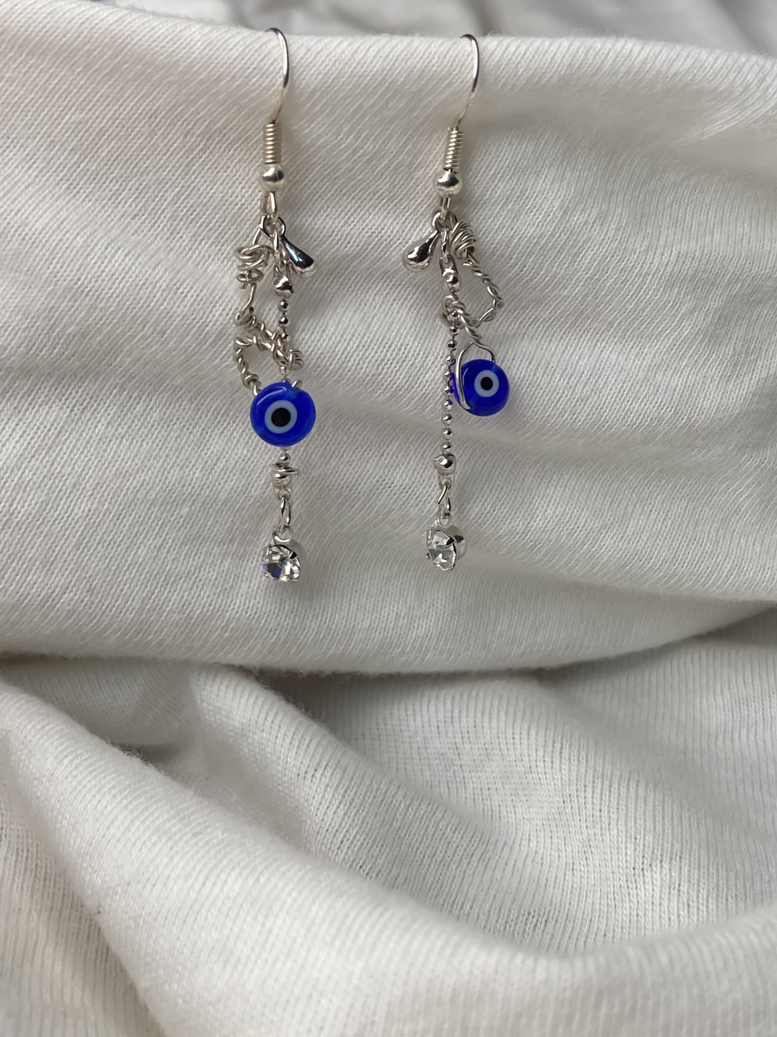 Handmade silver wire wrapped evil eye dangle drop earrings.