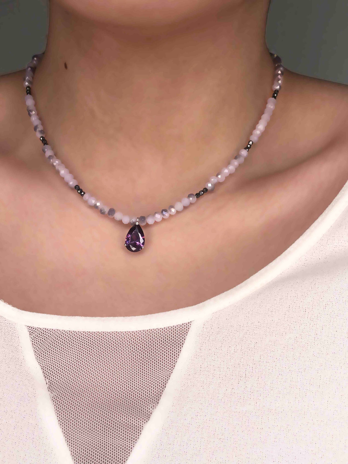 Handcrafted light purple and black crystal beaded necklace with a silver backed amethyst stone