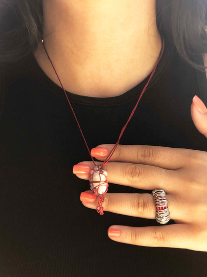 handcrafted red and silver wire wrapped seashell pendant with clear and red crystal beads and adjustable knot ties.