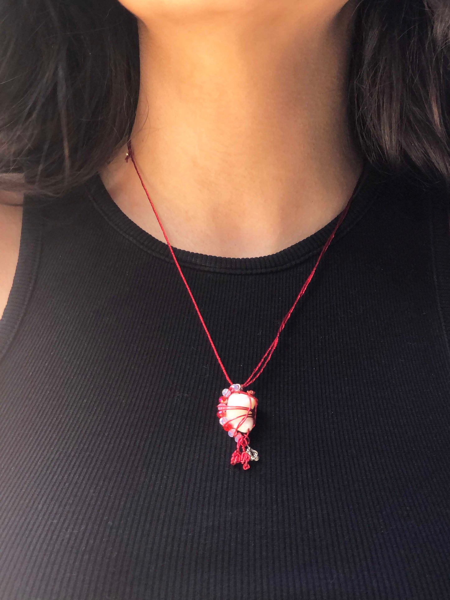 handcrafted red and silver wire wrapped seashell pendant with clear and red crystal beads and adjustable knot ties.