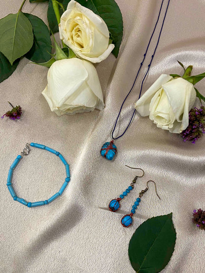 A pair of handcrafted wire-wrapped and beaded turquoise earrings, a matching pendant necklace, and beaded bracelet.