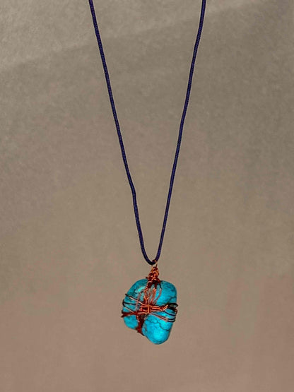 A handcrafted wire-wrapped turquoise stone pendant necklace.