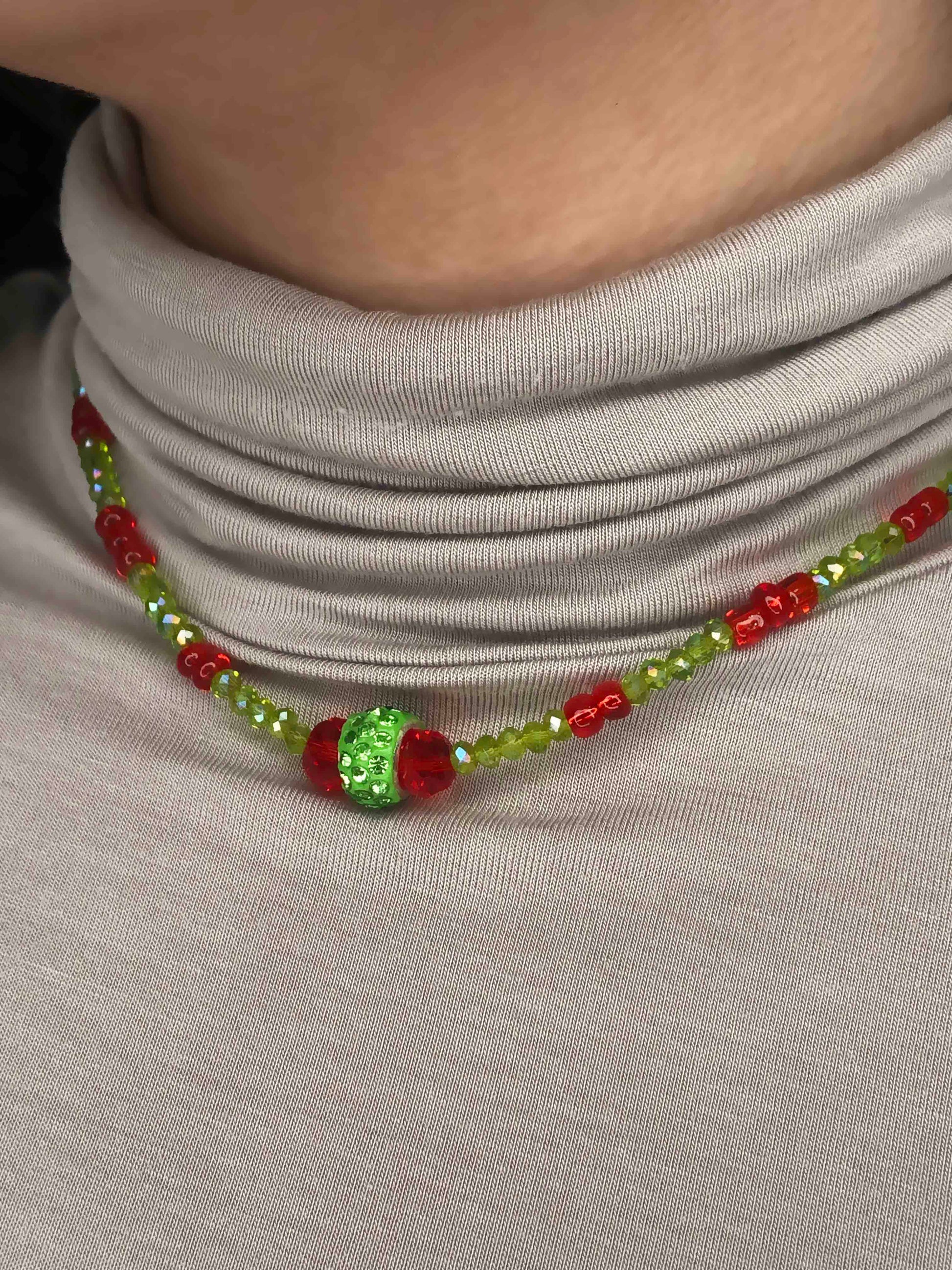 Handcrafted red and green crystal beaded necklace with rhinestone charm at its center.