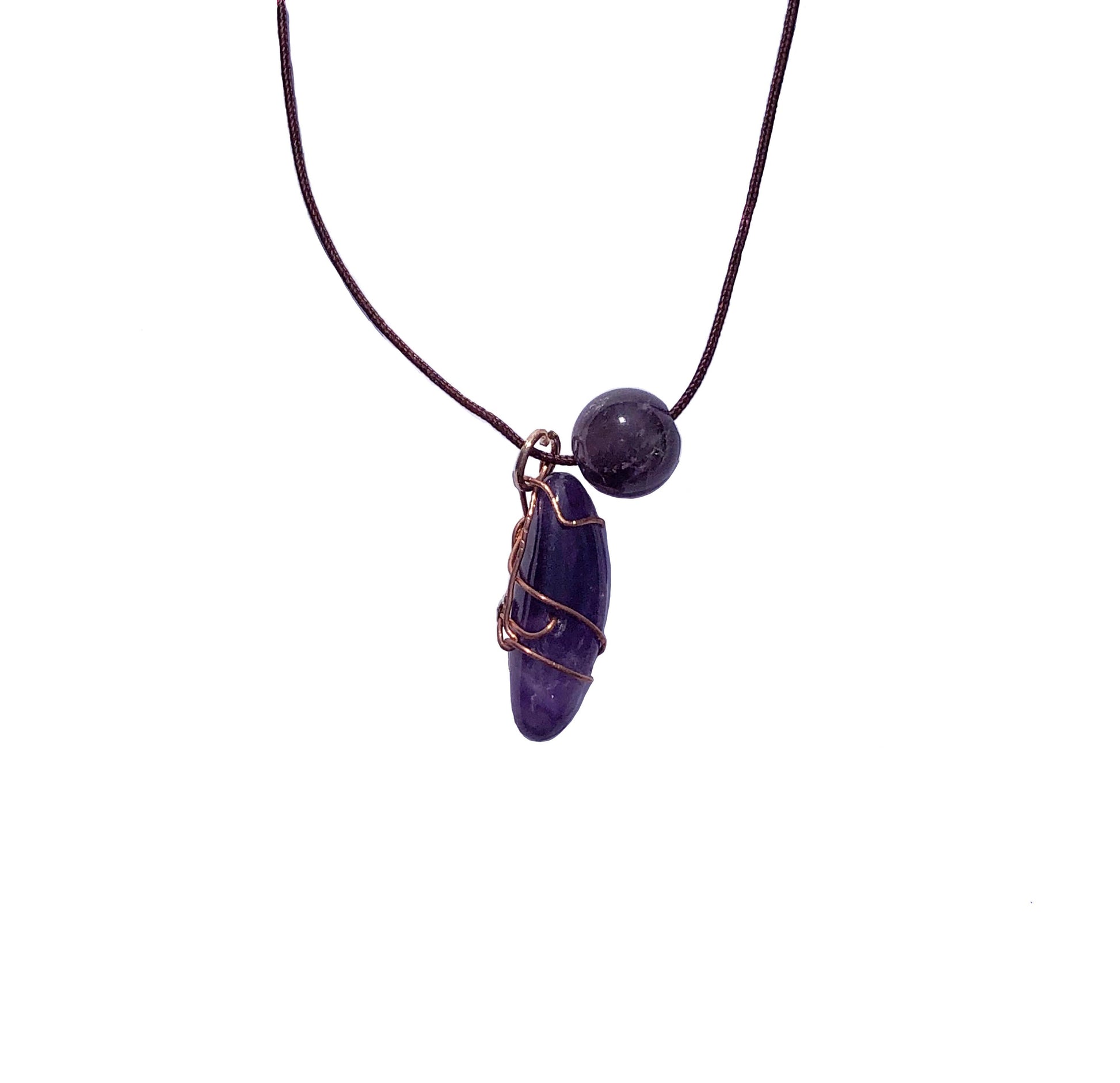 copper wire wrapped amethyst stone with a large purple glass bead 