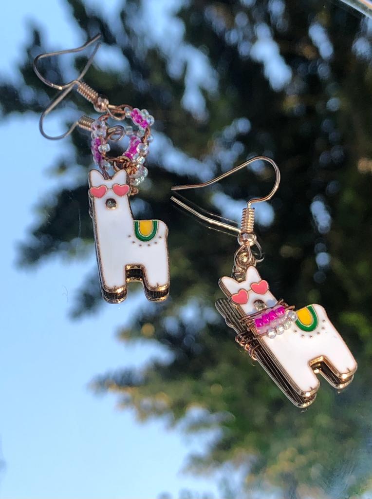 Asymmetric pair of handcrafted pink and clear beaded earrings with two heart eyed llama charms