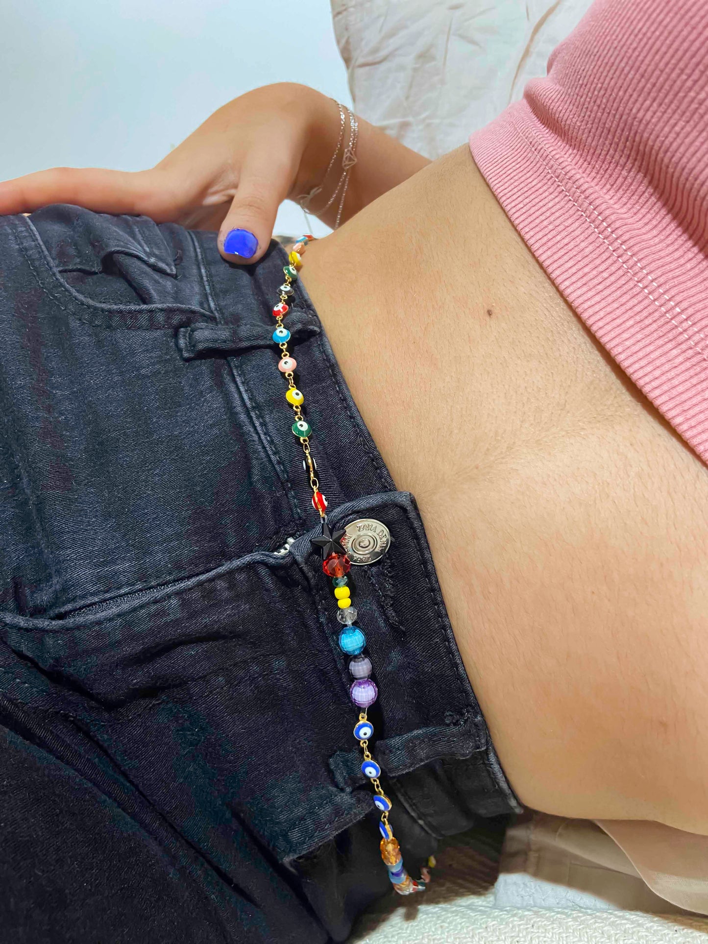A handcrafted glass and crystal beaded belly chain with multicolor evil eye charm chains.