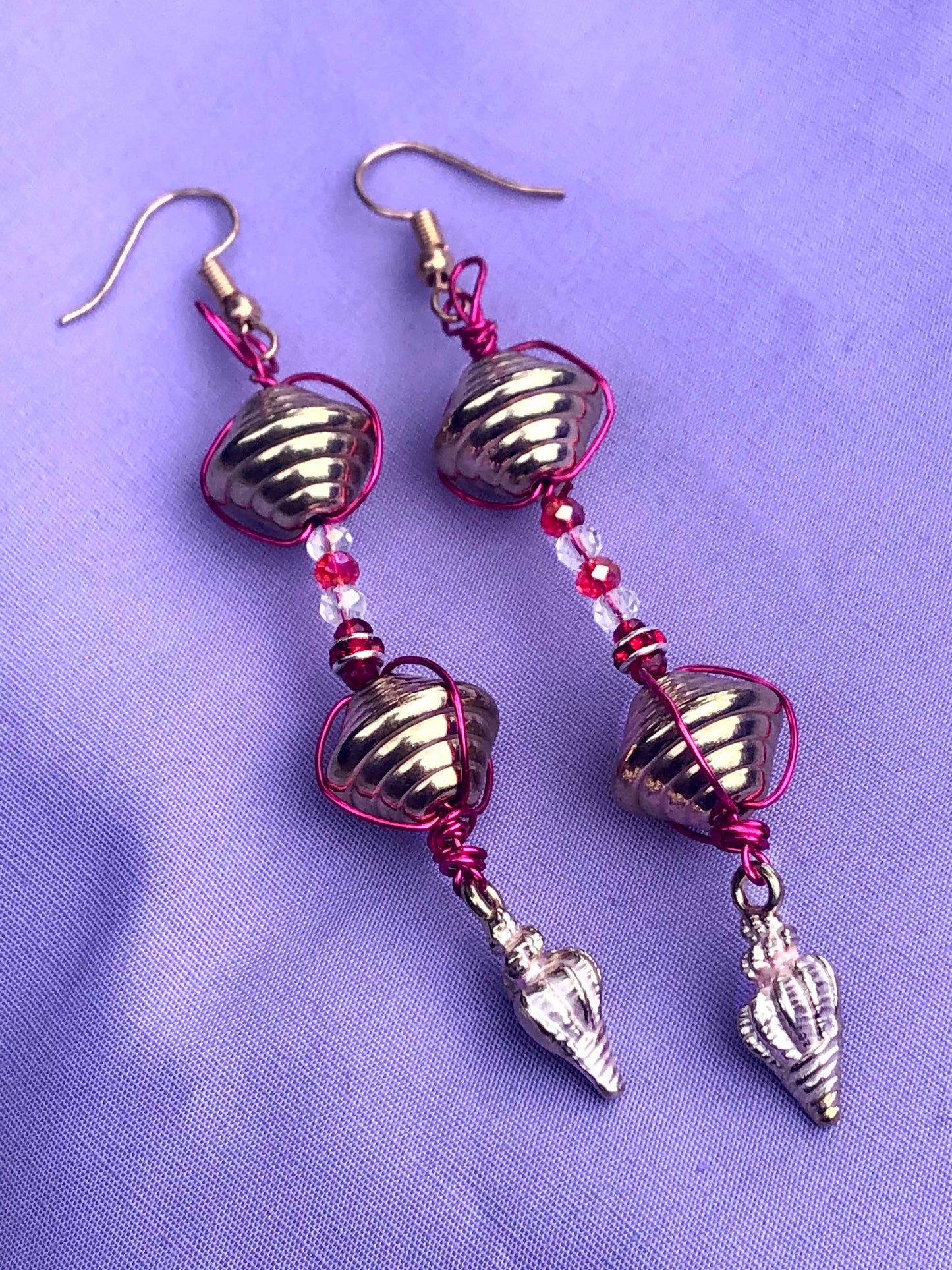 Handcrafted pink wire wrapped, beaded clear and red crystal earrings with golden and seashell charms.