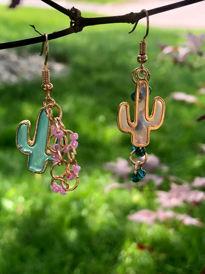 handcrafted mismatched pair of pink and blue beaded chain link earrings with green and pink cactus charms.