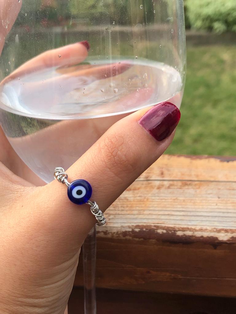 Handmade silver wire wrapped blue evil eye charm ring.