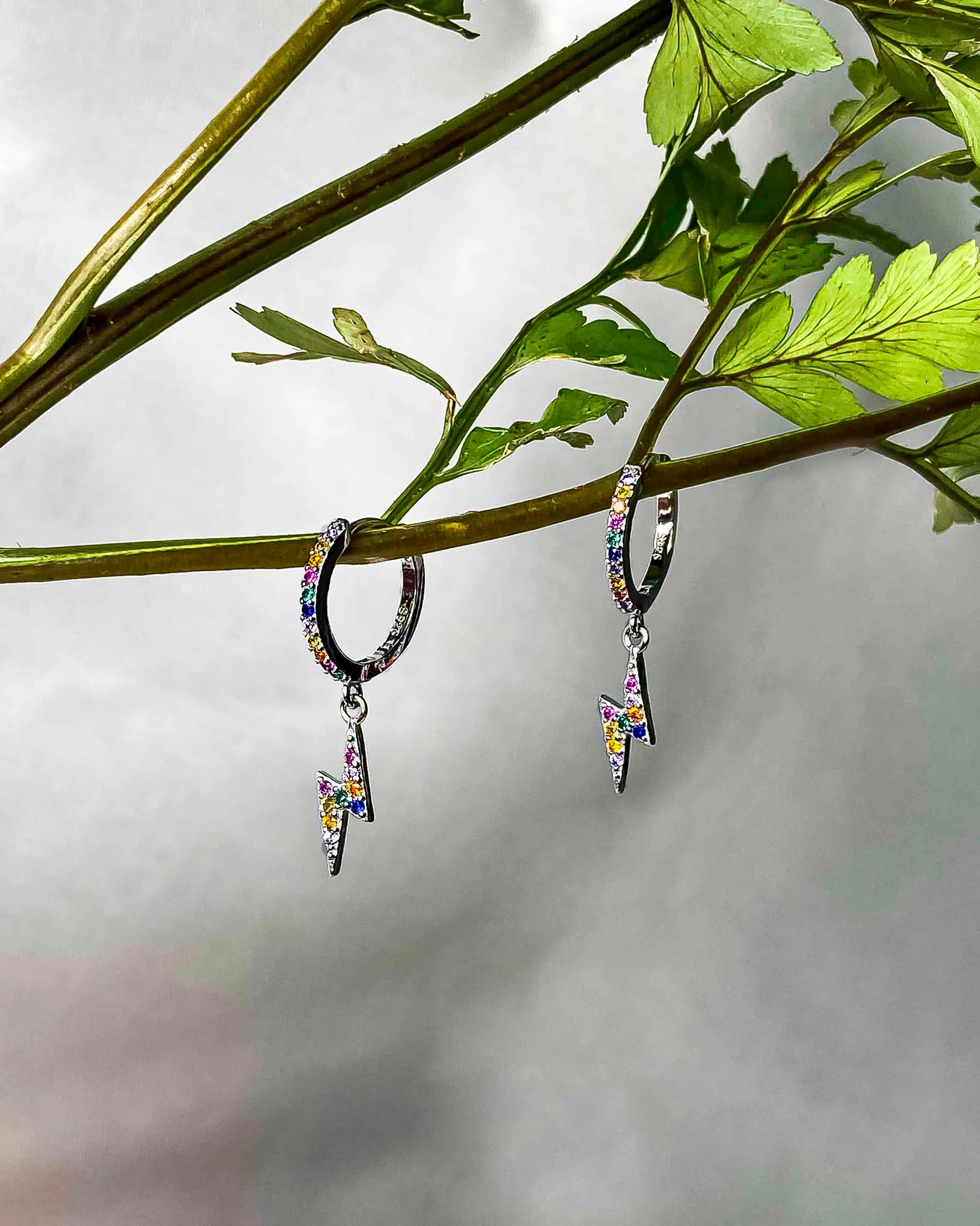  925 sterling silver huggie hoop lighting bolt earrings with multicolored zirconia stones.
