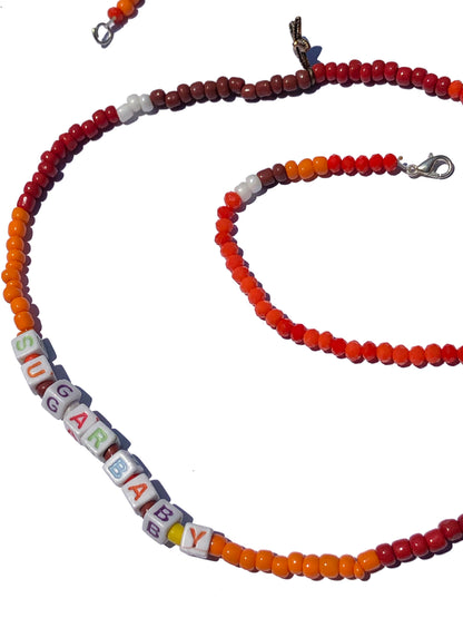 handcrafted orange, red, brown and white beaded belly chain with starfish charms and beaded letters.