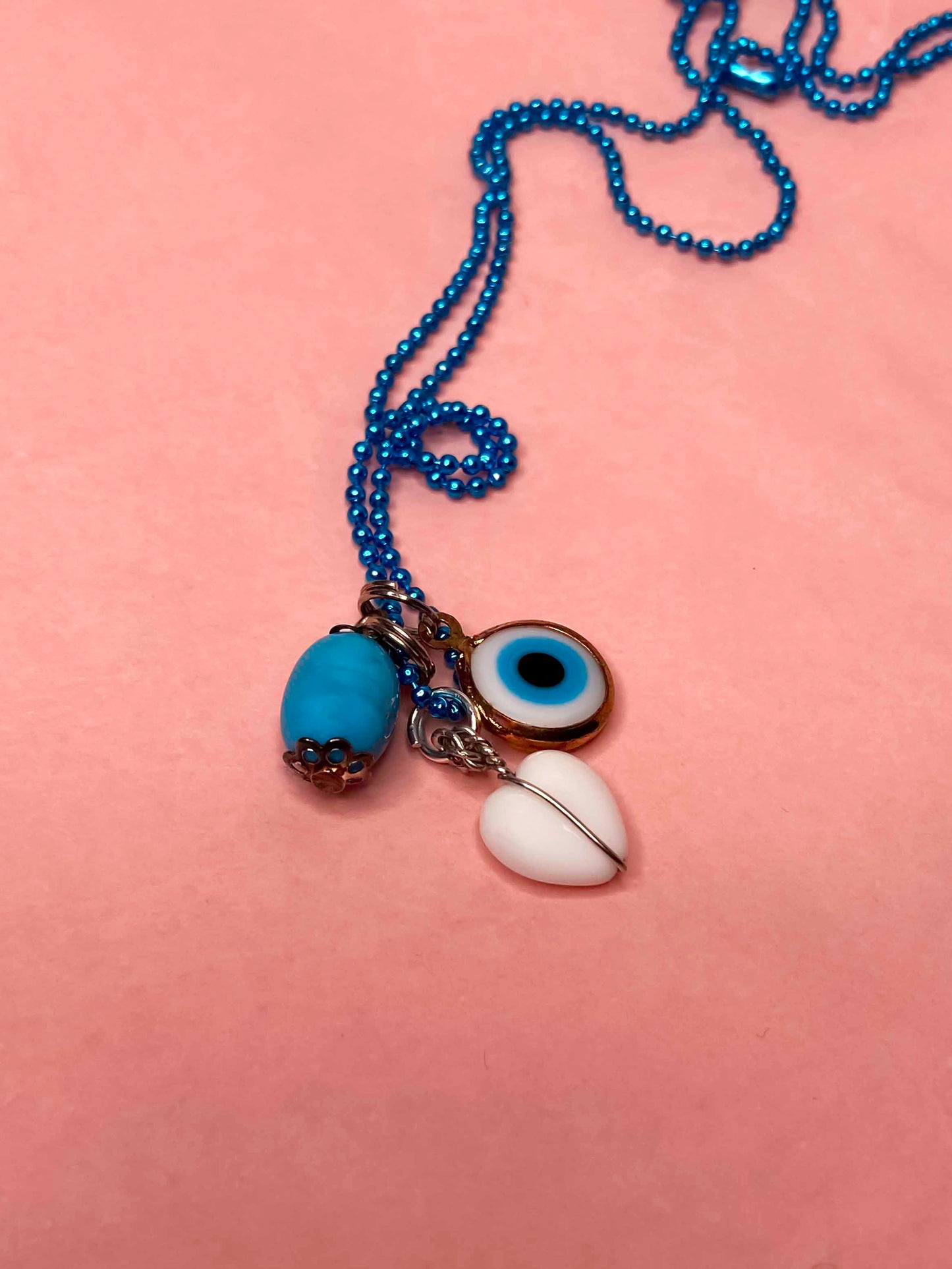 Handmade turquoise stone, evil eye, and white heart charm pendant. 
