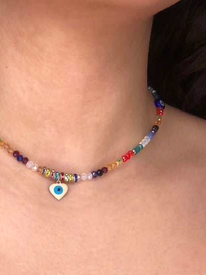 multicolored crystal beaded choker necklace with two circular blue evil eye charms, and a heart shaped evil eye pendant.